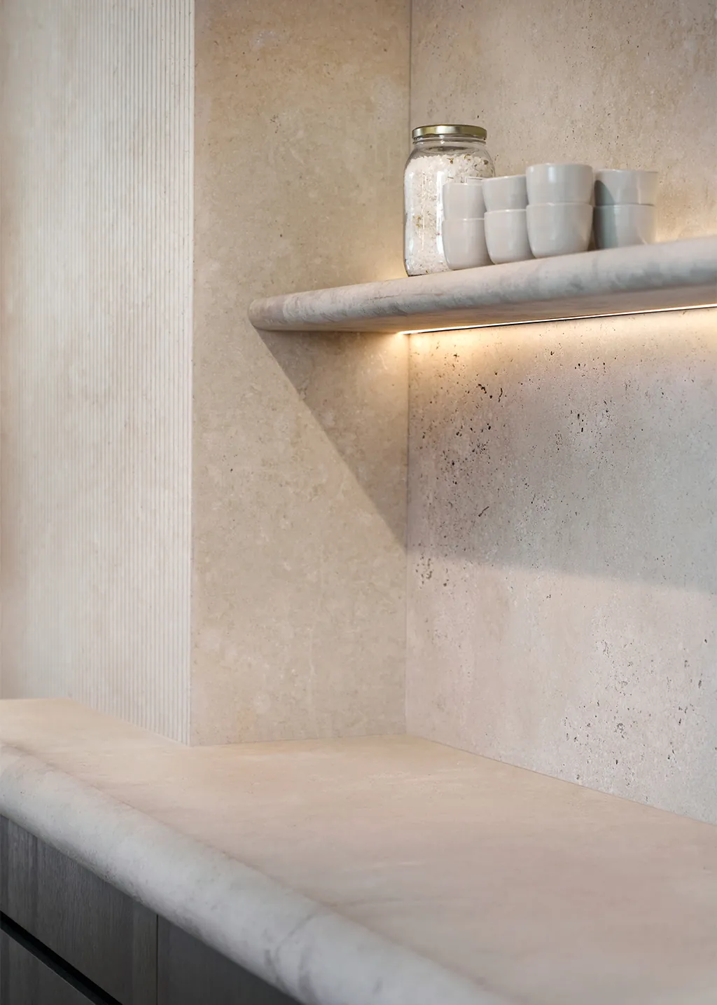 Luxe Eggersmann Japandi keuken met travertin natuursteen wandplank in organische ronde vormen, bruine greploze kastfronten en sfeervolle keukenverlichting